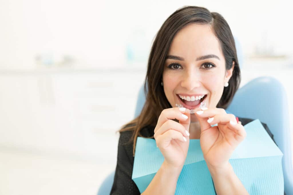 Young woman holding Invisalign braces