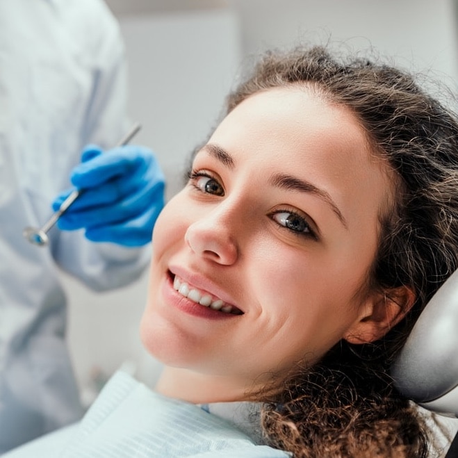 Smiling young woman receiving dental checkup. close up view. Healthcare and medicine concept.