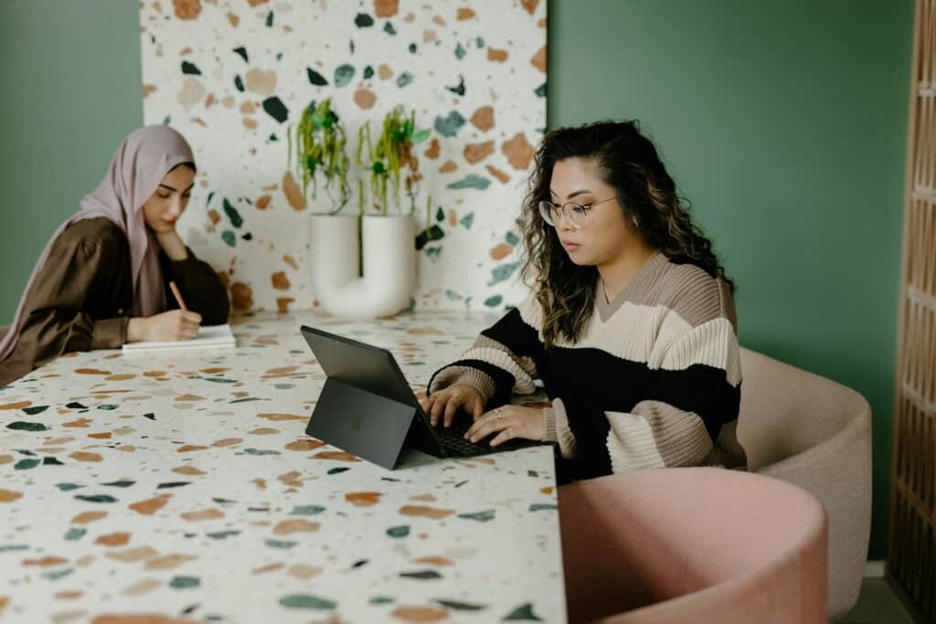 Two young women sitting at a table working